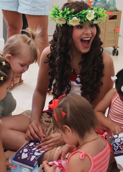Island princess character doing sticker crafts with kids