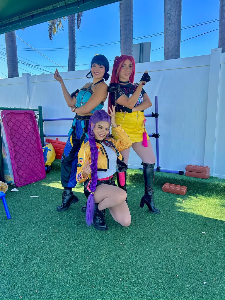Three character performers posing together outdoors