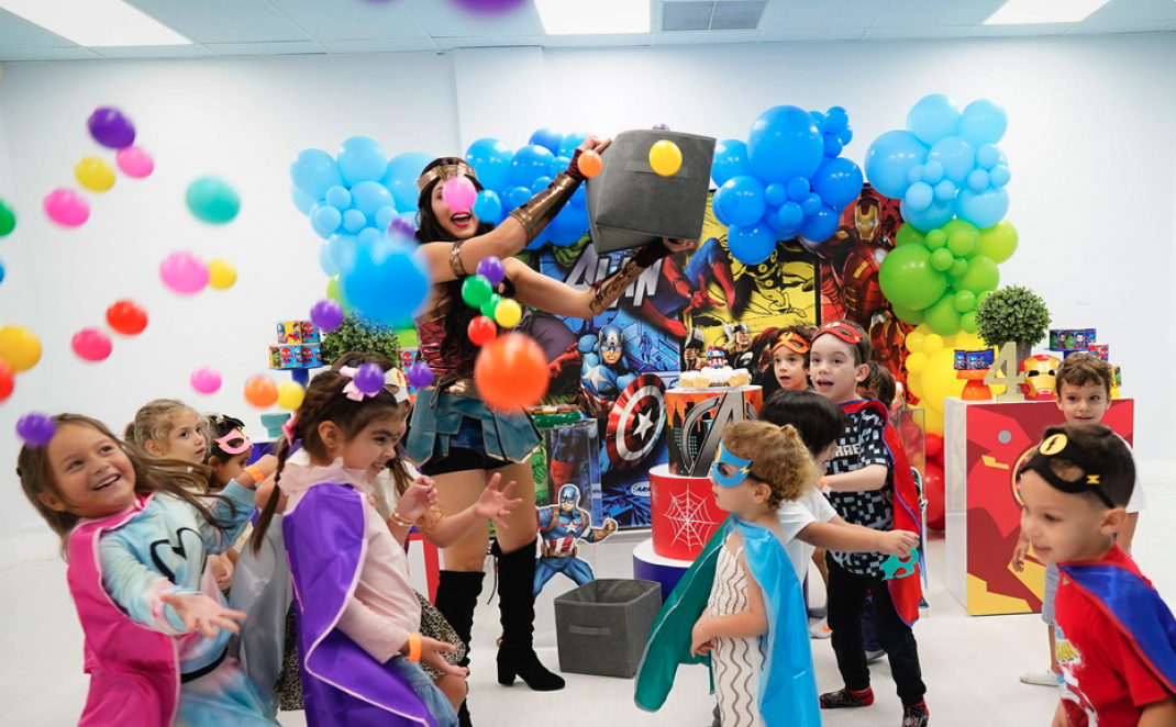 Superhero character playing with kids at a party