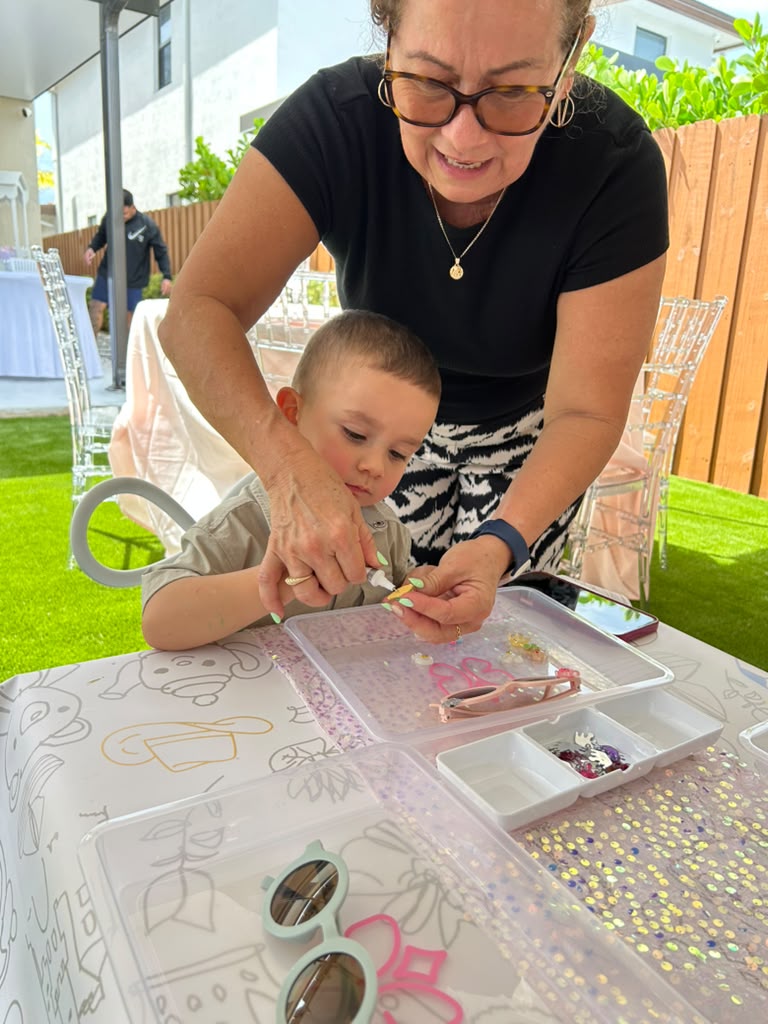 Artist helping a little one decorate his sunglasses