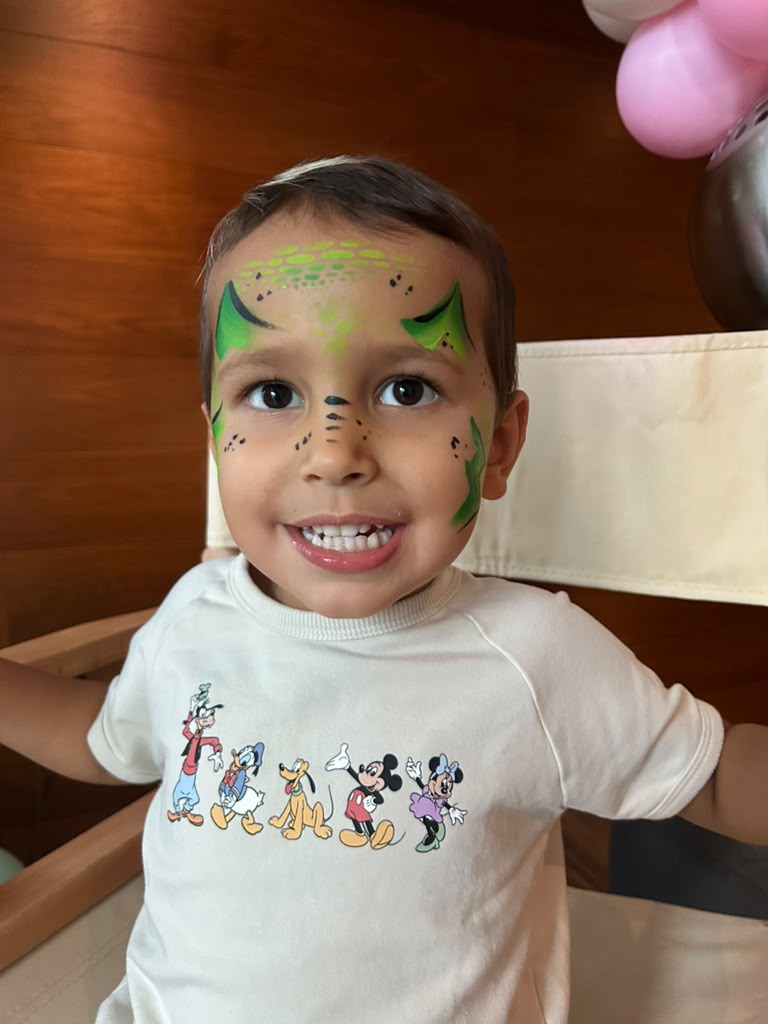 Toddler with green dinosaur face painting