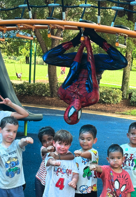 Spider hero character posing with kids at a playground party