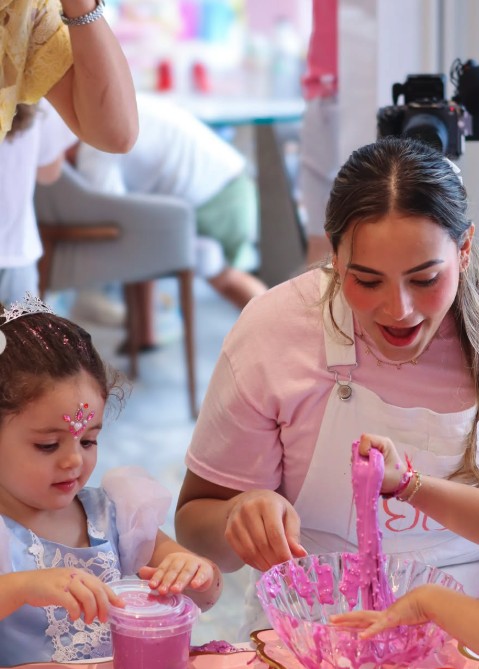 Artist making pink slime with a little girl