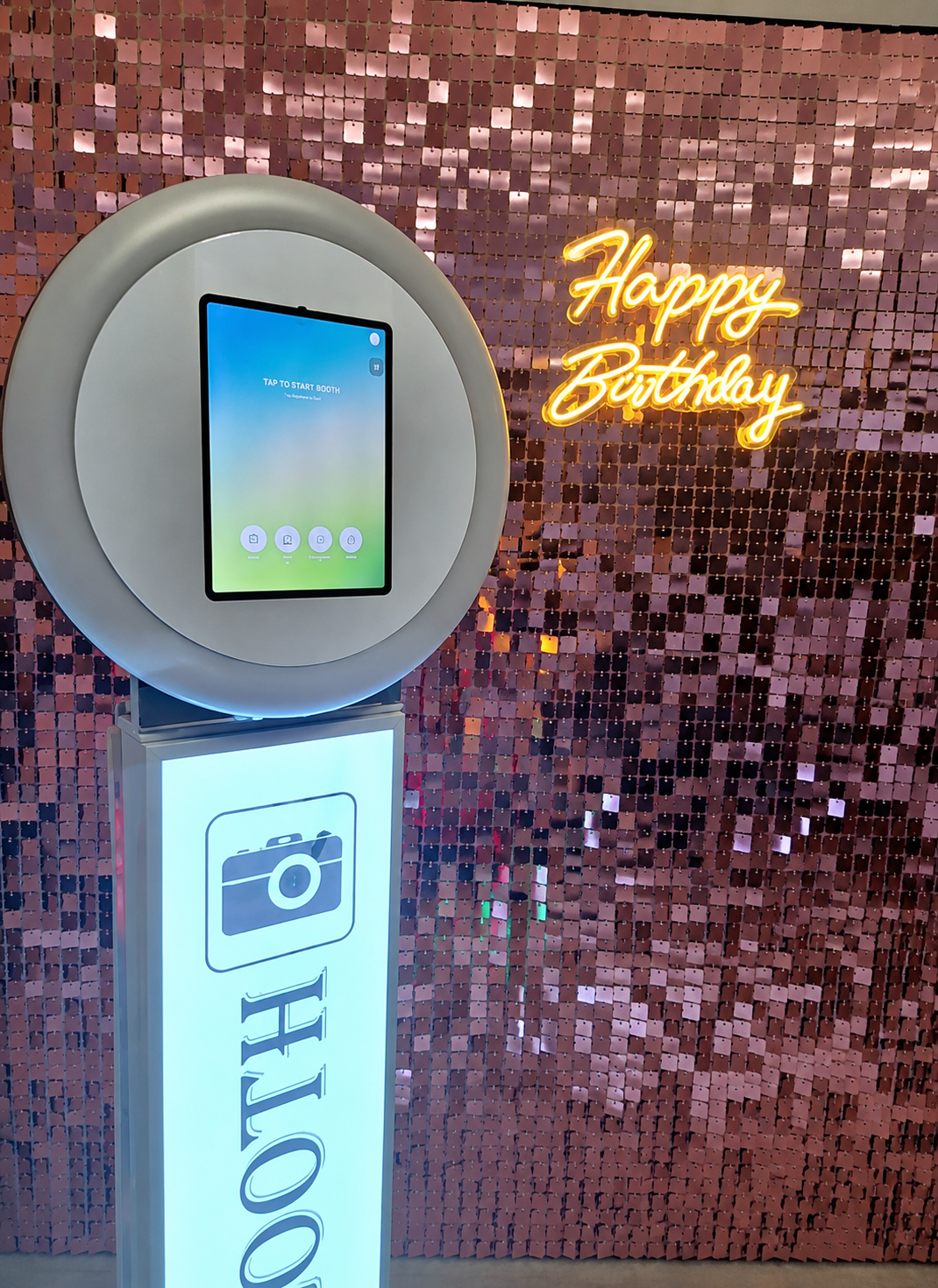 Digital photo booth with a ring light in front of a sequin backdrop