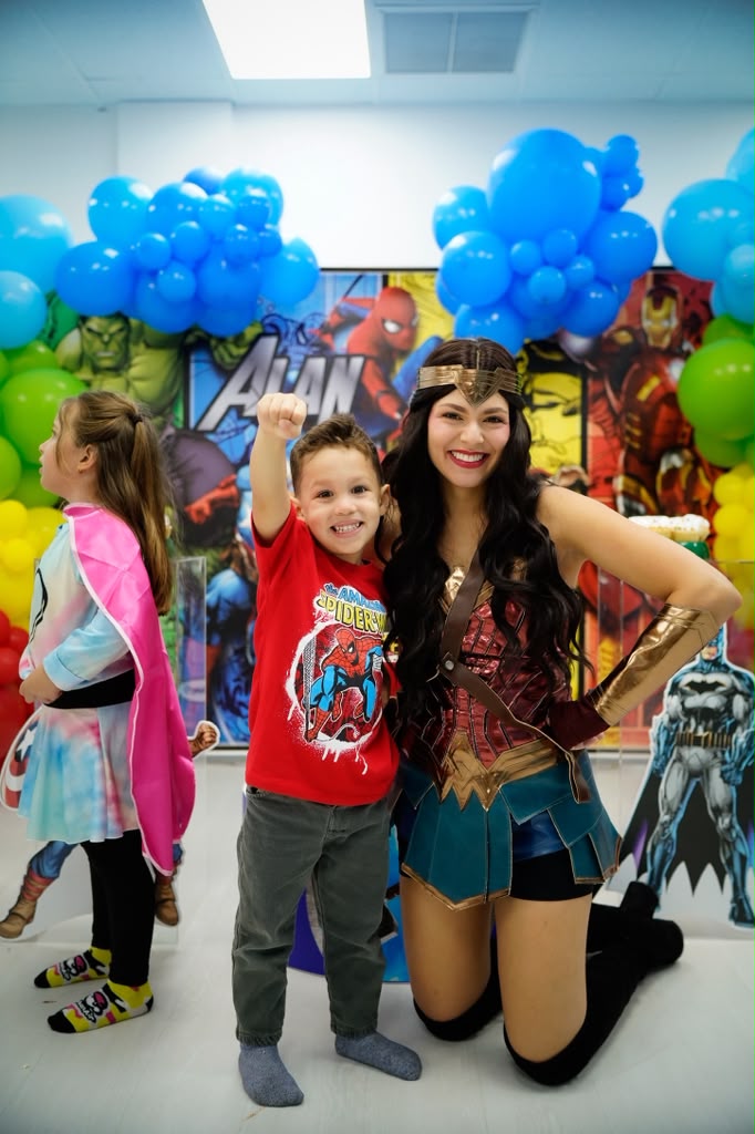 Wonder Woman character with kids at a superhero themed party