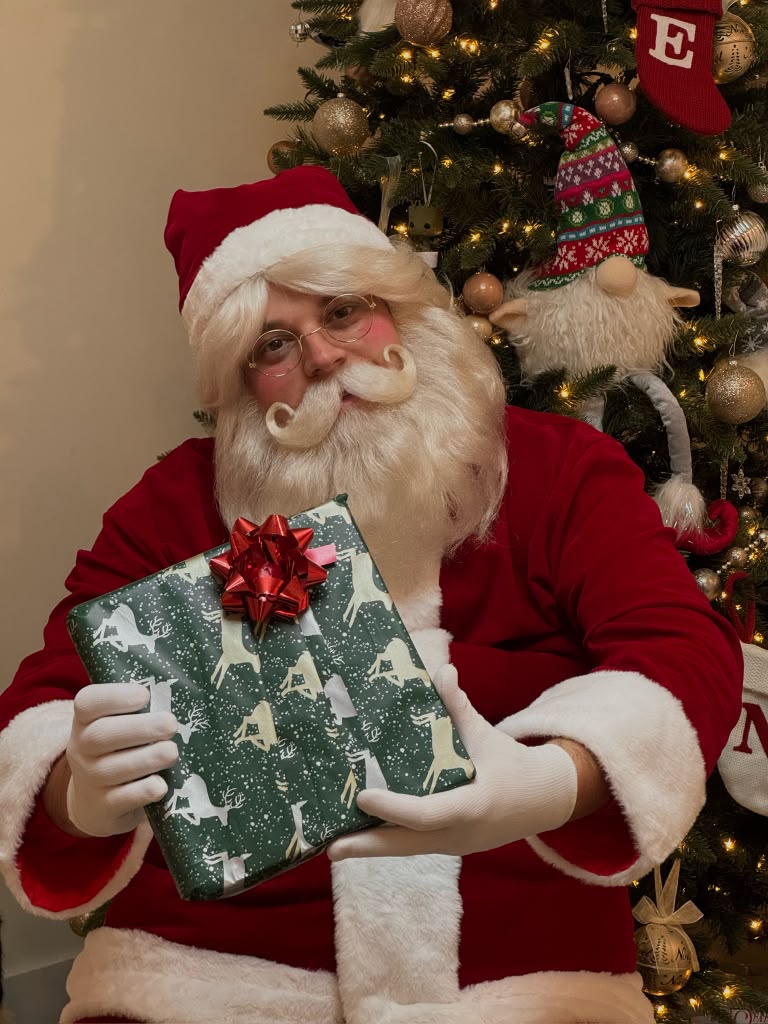 Santa Claus holding a wrapped Christmas gift