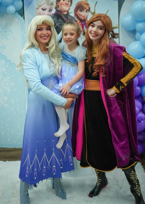 Snow sisters characters holding a birthday girl