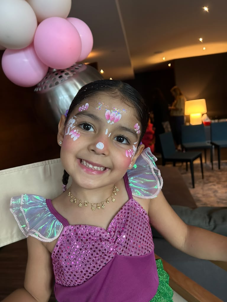 Girl with mermaid inspired face painting and glitter