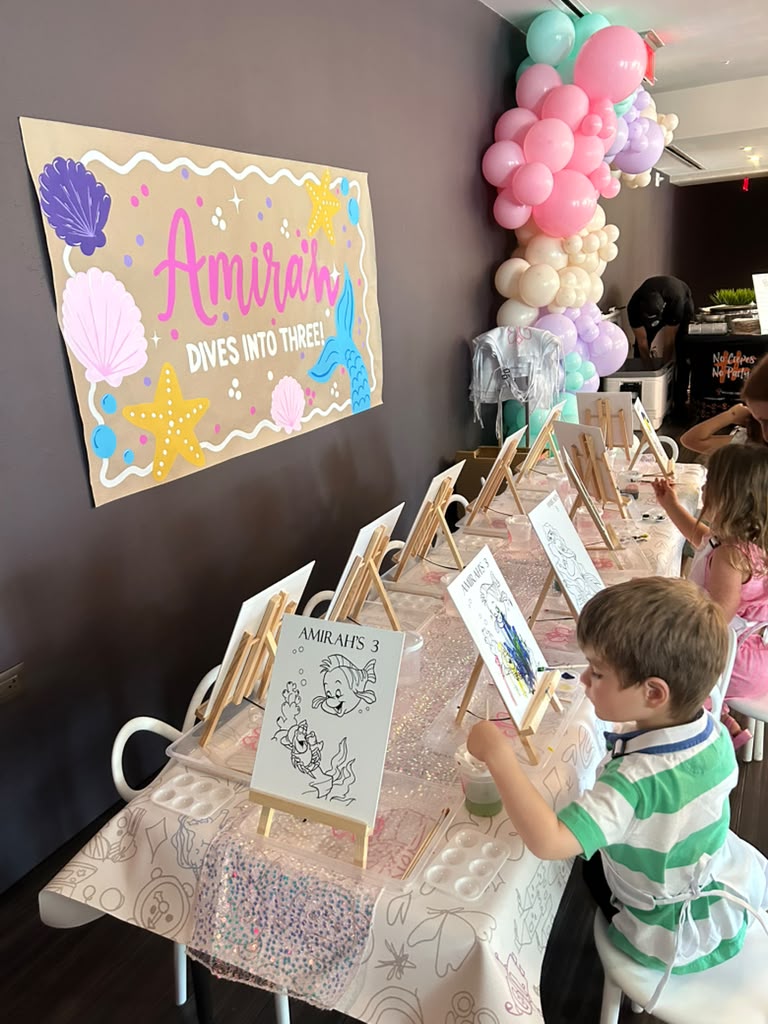 Kids painting mermaid canvases at a themed birthday party