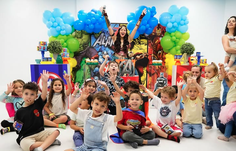 Kids cheering with hands up at a superhero themed party
