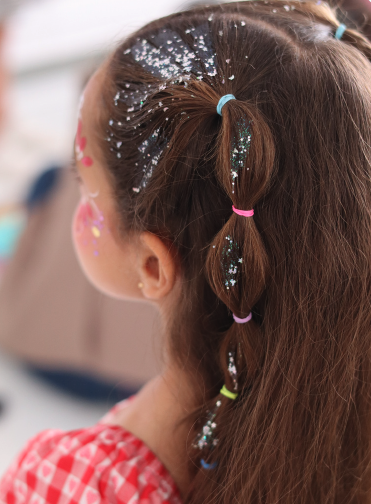 Kid with a sparkling braided hairstyle and glitter
