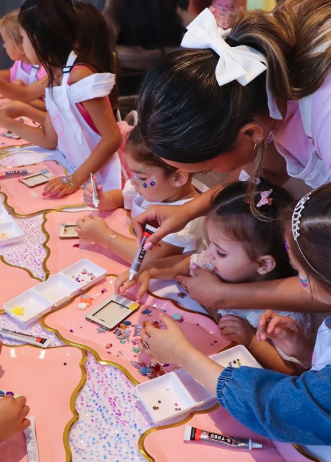 Kids decorating photo frames at the Creative Corner table