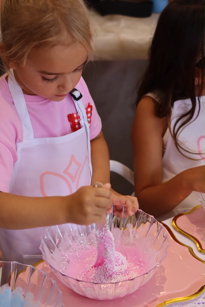 Girl mixing pink sparkly slime in a bowl