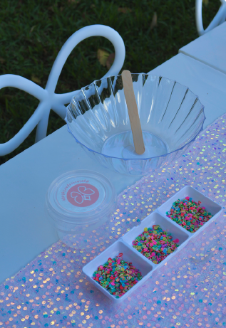 Slime bowl with sprinkles and add-ons on a sparkling table