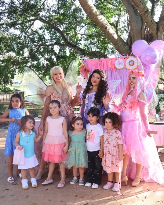 Fairy characters with a group of kids at a garden party