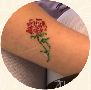 Glitter tattoo of a rose on an arm
