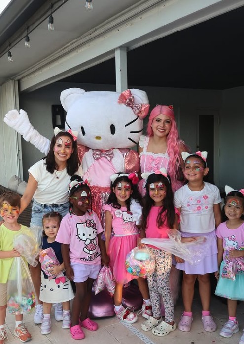 Kitty mascot and face painted kids at a party