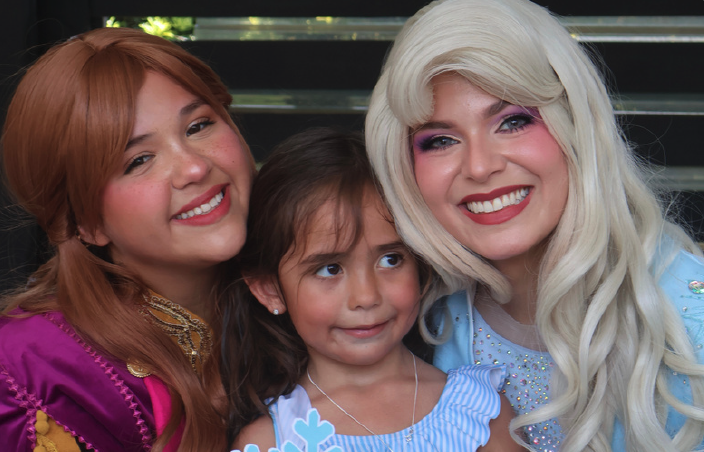 Snow sisters characters smiling with a birthday girl