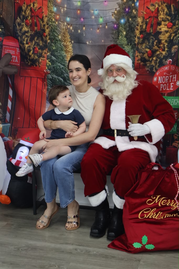 Mom and toddler posing with Santa at the North Pole setup